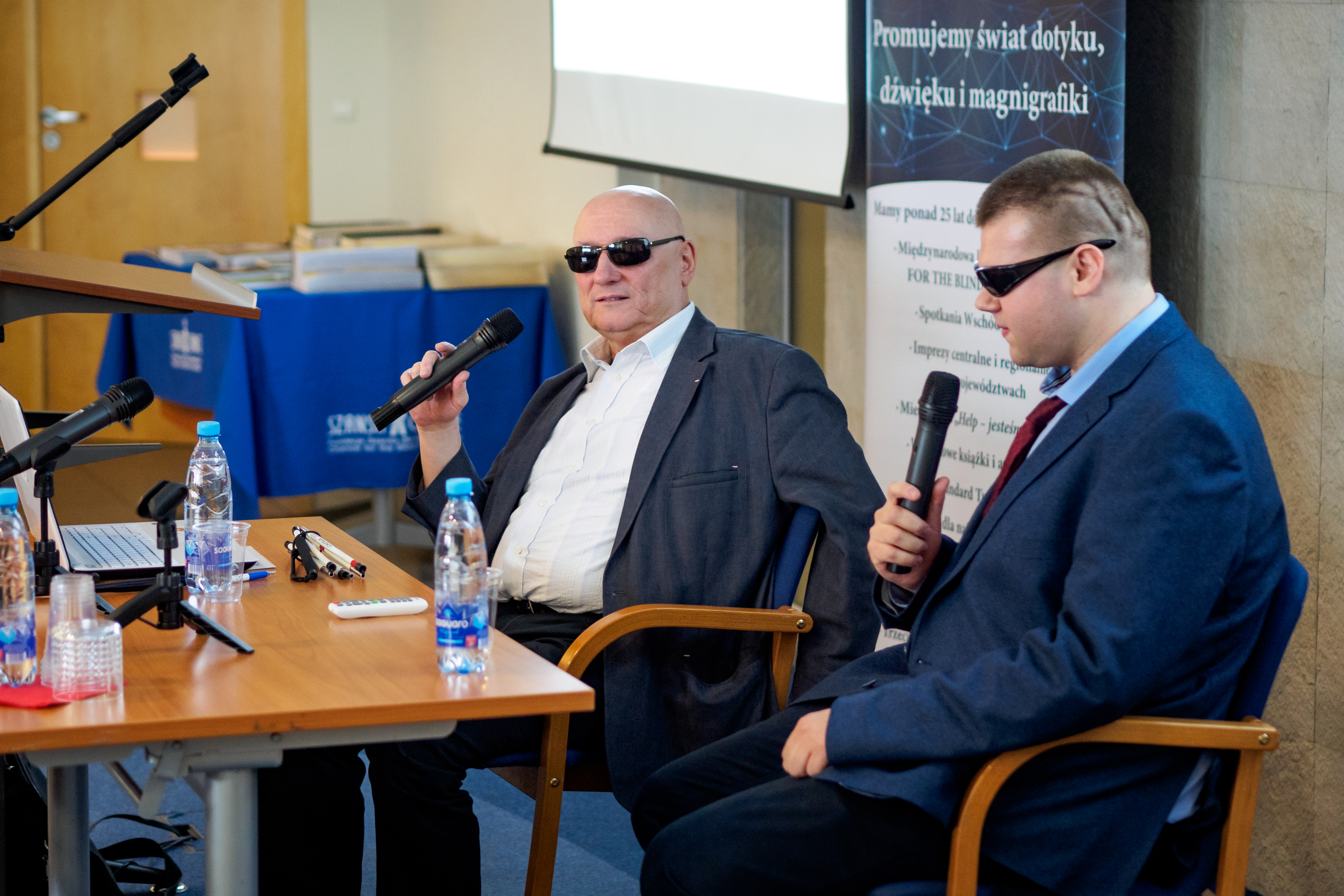 Dwóch niewidomych mężczyzn przy stole. Jednym z nich jest Pan Marek Kalbarczyk. 