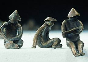 3 statuetki IDOLA, siedzące postacie, każda w innej pozycji